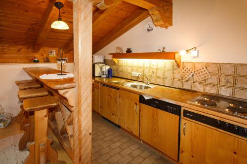 uma cozinha com armários de madeira e um lavatório em Ferienwohnung Hinterreiter em Ruhpolding