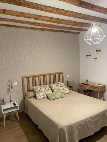 a bedroom with a large bed and a table at Hotel Rural El Cedro in Lerma