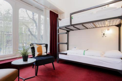 a bedroom with a bunk bed and a chair at Maverick Hostel & Ensuites in Budapest