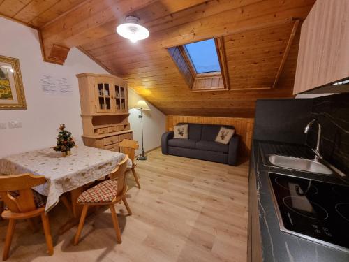 a kitchen and living room with a table and a couch at Cesa Elena in Canazei