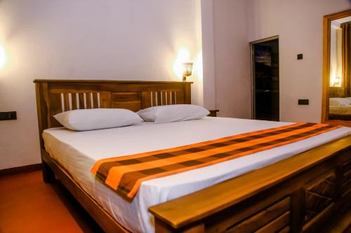 a bedroom with a large bed with a striped blanket at Little Angels in Mirissa