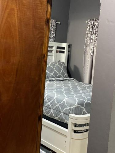 a small bedroom with a bed and curtains at Montego Bay, Ironshore Luxury Studio in Montego Bay