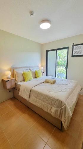 1 dormitorio con 1 cama grande con almohadas amarillas en 2 Br Condo Unit Cagayan de Oro City en Cagayán de Oro