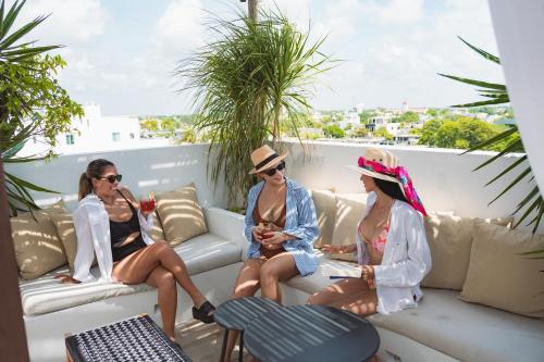 drie vrouwen op een bank op een balkon bij Terrasse Hotel Playa del Carmen in Playa del Carmen