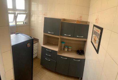 uma pequena cozinha com um frigorífico preto num quarto em Vista Maravilhosa em São Vicente
