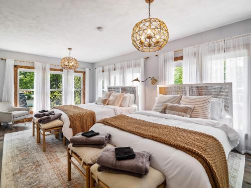 1 Schlafzimmer mit 2 Betten und einem Kronleuchter in der Unterkunft Welcome To Wine Country - Relaxed Luxury in Geneva