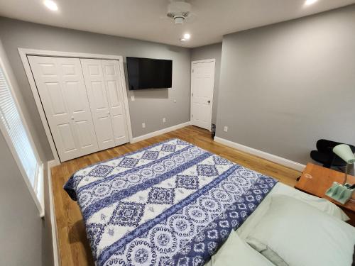 a bedroom with a bed and a flat screen tv at RobbinsStreetWaltham in Waltham