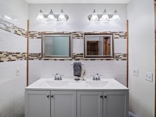 ein Badezimmer mit zwei Waschbecken und zwei Spiegeln in der Unterkunft Welcome To Wine Country - Relaxed Luxury in Geneva