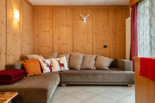 a couch in a room with wooden walls at Apartment Pordoi in Campitello di Fassa
