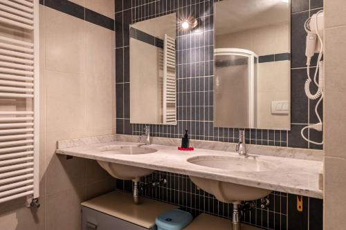 a bathroom with two sinks and a mirror at Apartment Pordoi in Campitello di Fassa