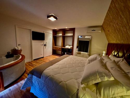 um quarto com uma cama grande e uma casa de banho em La Vie Pousada de Charme em Campos do Jordão