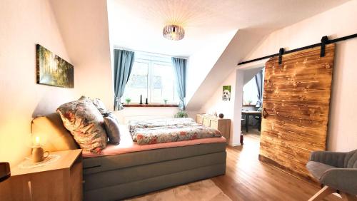 ein Schlafzimmer mit einem Bett und einem großen Fenster in der Unterkunft Ferienwohnung Berglodge 22 Hahnenklee Bockswiese in Goslar