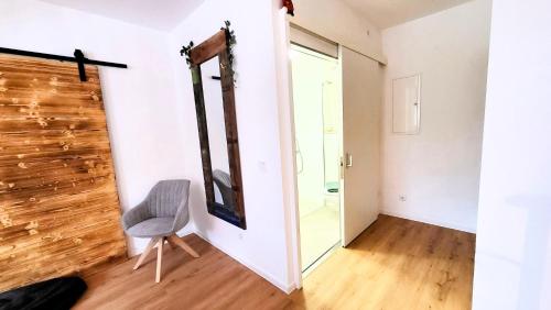 Pokój z krzesłem i lustrem na ścianie w obiekcie Ferienwohnung Berglodge 22 Hahnenklee Bockswiese w mieście Goslar