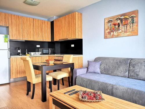 a living room with a couch and a table and a kitchen at Mladost Apartments Sofia in Sofia