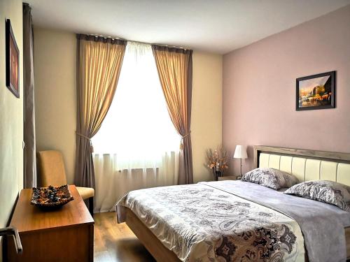 a bedroom with a bed and a large window at Mladost Apartments Sofia in Sofia