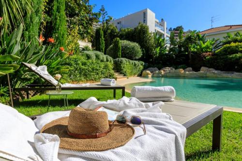 - un chapeau et des serviettes assis sur un banc à côté de la piscine dans l'établissement Luxury Villa Nice, à Nice