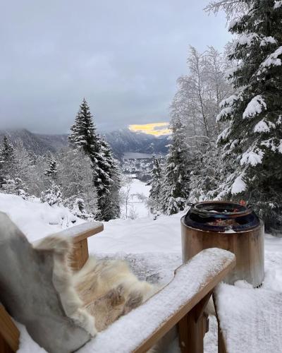 a snow covered bench with a fire in the snow at Vidsyn Midjås in Vistad