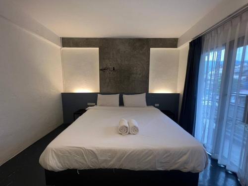 a bedroom with a bed with two white towels on it at isleep guesthouse in Chiang Mai