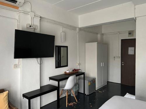 um quarto com uma secretária e uma televisão na parede em isleep guesthouse em Chiang Mai