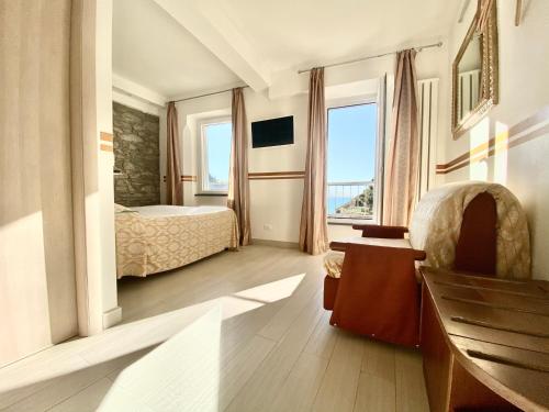 1 dormitorio con cama y ventana grande en The Manarola Main Plaza, en Manarola