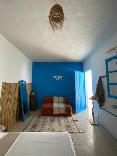 a blue room with a couch and a blue wall at Wostel Djerba in Erriadh