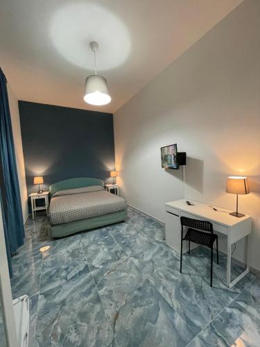 1 dormitorio con cama, escritorio y mesa en Dante Rooms, en Nápoles