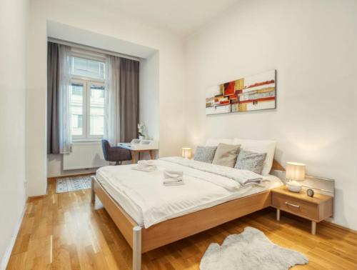 a white bedroom with a bed and a desk at Flarent Vienna Apartments-HG in Vienna