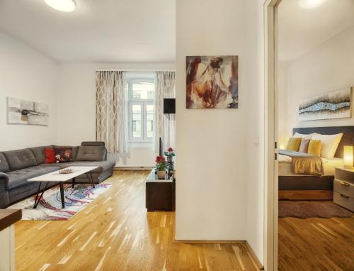 - un salon avec un canapé et un lit dans l'établissement Flarent Vienna Apartments-HG, à Vienne