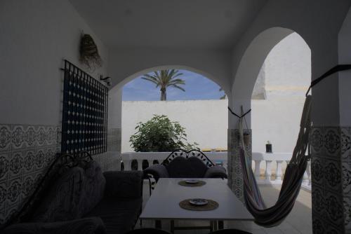 um quarto com uma mesa e cadeiras e uma janela em Wostel Djerba em Erriadh