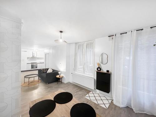 un salon blanc avec un canapé et une table dans l'établissement L'Empreinte Stéphanoise, à Saint-Étienne