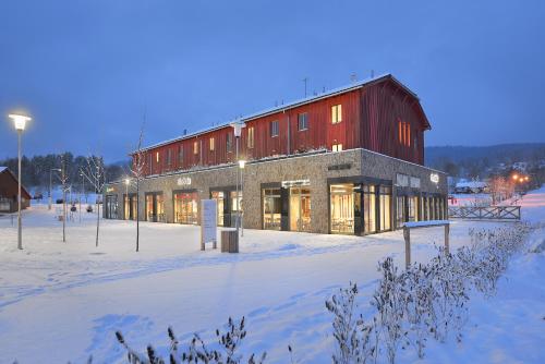 a large red building in the snow at night at Hotel Element in Lipno nad Vltavou