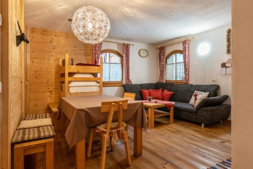 a living room with a table and a couch at Dolomitc Tobià in Campitello di Fassa