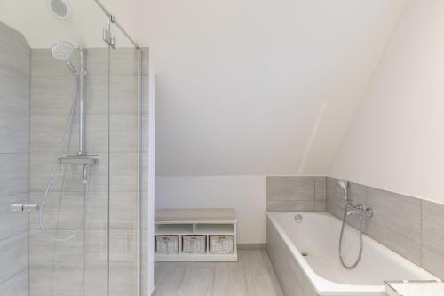 a bathroom with a shower and a bath tub at Kleine Flucht in Tating