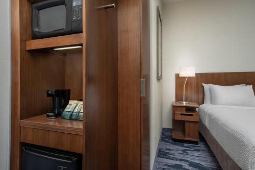 a hotel room with a bed and a television at Fairfield Inn & Suites by Marriott Ithaca in Ithaca