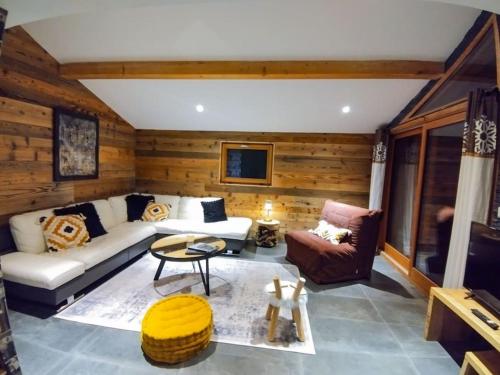 a living room with a couch and a table at Chalet spacieux & spa in Landry