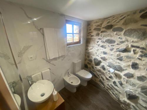 a bathroom with a toilet and a sink at Casa Rosmaninho - Izei in Chaves