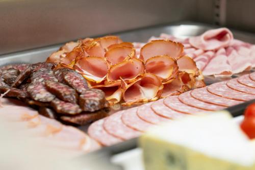 a plate of food with meat and pretzels at Hotel Angelika in Neustift im Stubaital