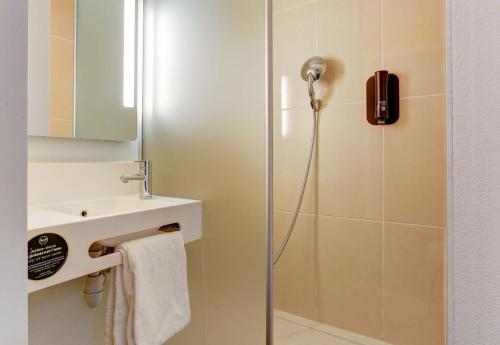 a bathroom with a shower and a sink at B&B HOTEL Reims Centre Gare in Reims