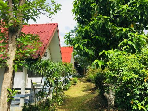 una casa con techo rojo en un bosque en LungYod guesthouse, en Ban Tha Ling Lom