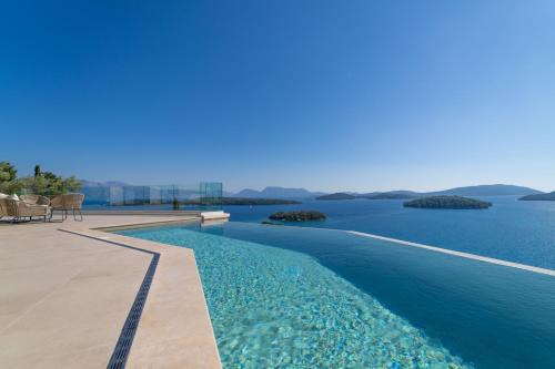 a swimming pool with a view of the water at Smirties Villas in Nydri