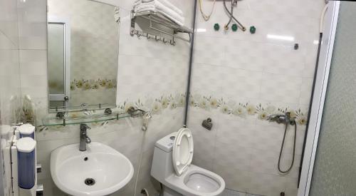 een badkamer met een douche, een toilet en een wastafel bij Thiên Hương Hotel in Làng Lap