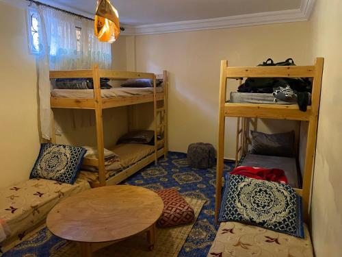 a room with two bunk beds and a table at Imssouane cathédrale in Imsouane