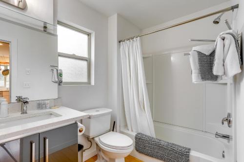 ein weißes Bad mit einem WC und einer Dusche in der Unterkunft Modern Tukwila Apartment with Balcony Near Airport! in Tukwila