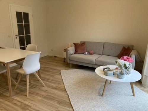 a living room with a couch and a table at moderne 2-Zimmer-Wohnung mit Terrasse in Tönnhausen