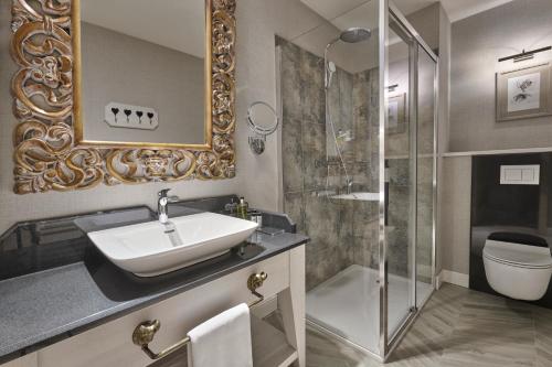 a bathroom with a sink and a shower at Aries Hotel & SPA Szczyrk in Szczyrk