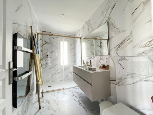 une salle de bain blanche avec un lavabo et une douche dans l'établissement 3160-Maison avec piscine avec 8 couchages, à Banyuls-dels-Aspres