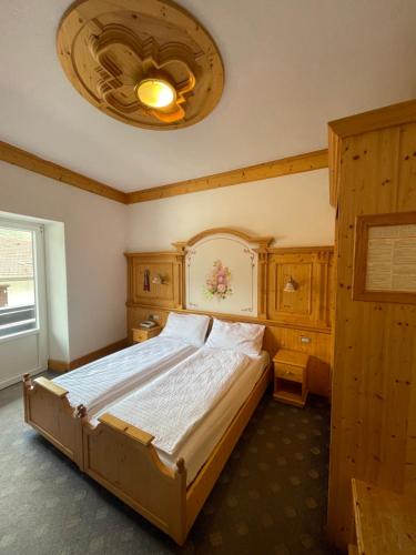 a bedroom with a large bed with a ceiling at Villaggio Hotel Aquila in Calliano