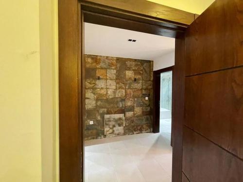 a hallway with a stone wall and a door at Horizon Villa in Amman