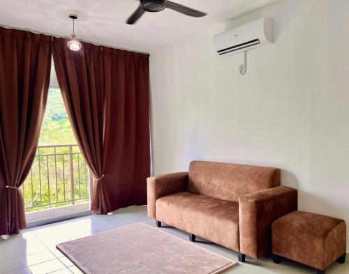 a living room with a chair and a window at Omak Kito Homestay Melaka in Kampong Alor Gajah