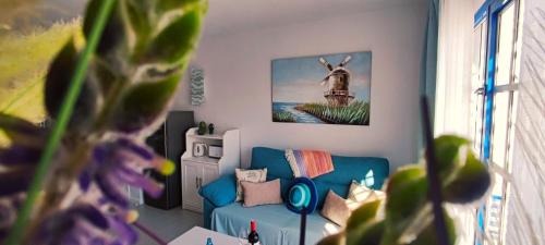 a living room with a blue couch and a picture of a deer at Apartamento Perla Atalaya in Puerto del Carmen